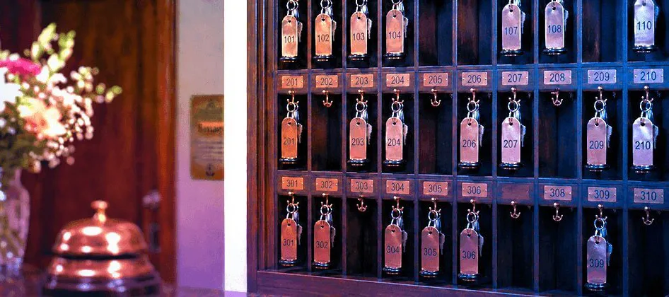 Schlüsselbrett an der Rezeption, davor eine Messingglocke